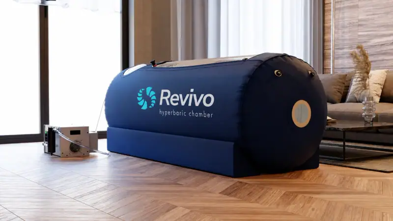 A Revivo soft-shell hyperbaric chamber set up in a living room